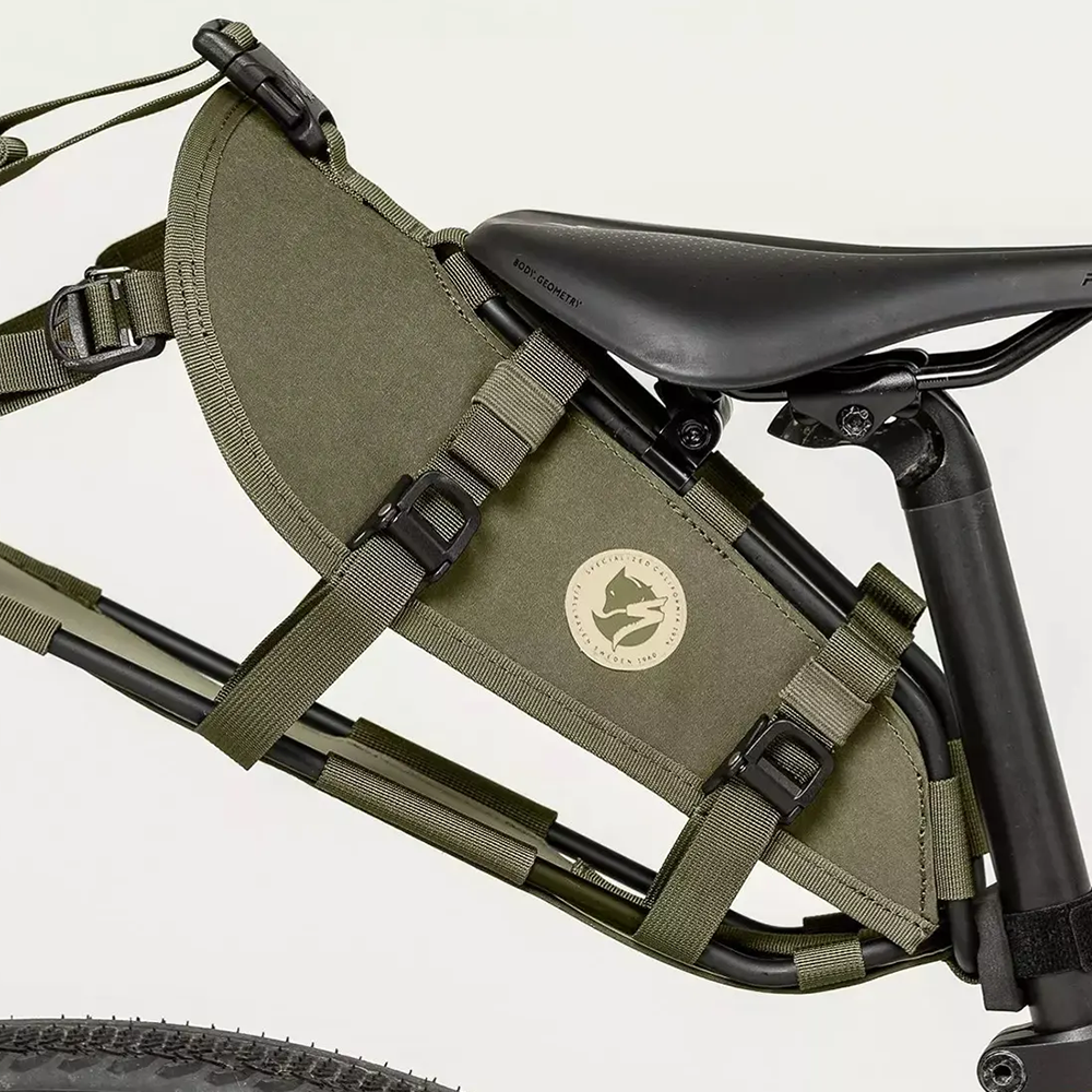 A green seatbag harness attached to a bicycle seat, designed for carrying gear on a bike.